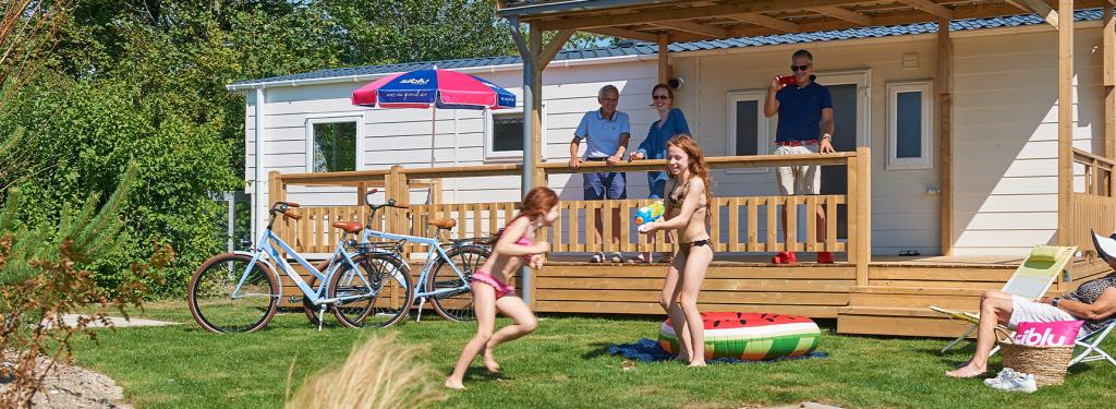 Famille devant mobil home au camping de Oase